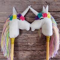 חד קרן על מקל עם שיער פסטל ופרח סגול