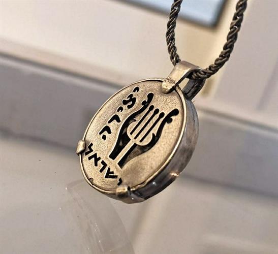 מטבע העצמה, To Be מאת ציפורה אוריה, תליון כסף בהשראת מטבע עתיק מימי בר כוכבא עם חריטת נבל דוד והמילה יצירה. מתנה ישראלית עם משמעות