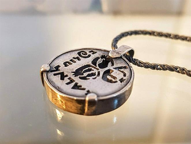 מטבע העצמה, To Be מאת ציפורה אוריה, תליון מטבע כסף עם סמל שלושת הרימונים והמילה בשלות