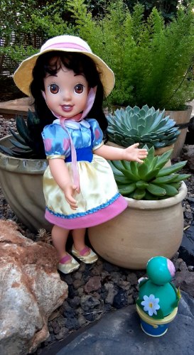 בובה גדולה של הנסיכה שלגיה הילדה, מוכנה לעבוד בגינה עם ידידה קקטוס מזמר