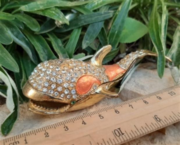 לוויתן קטן ומנצנץ עשוי מתכת , מקושט אבנים מנצנצות עם פה נפתח לאחסון אוצרות