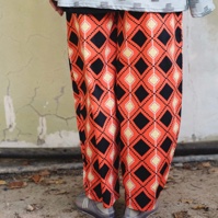 מכנסיים מדגם מיכאלה עם הדפס מעוינים על רקע בצבע כתום באווירת מקסיקו