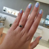 טבעת זהב משובצת יהלום שחור בחיתוך אליפסה ושורת יהלומים לבנים מסביב