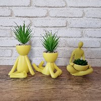 איש צהוב יושב מחזיק עציץ