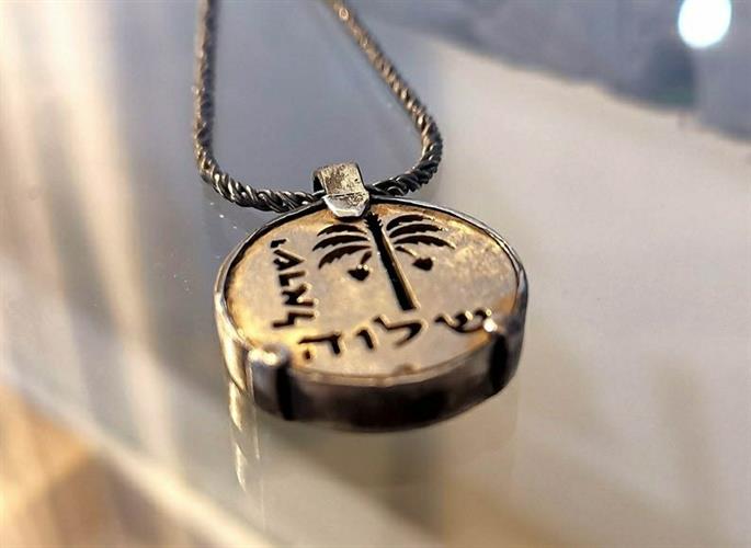 מטבע העצמה, To Be מאת ציפורה אוריה, תליון מטבע זהב וכסף עליו חרוט סמל עץ התמר, לקוח ממטבע עברי קדום מימי בר כוכבא