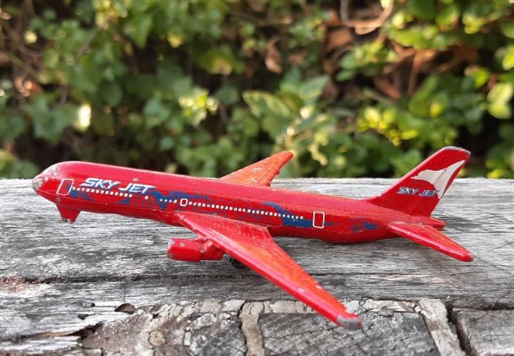 מטוס מתכת קטן, דגם של בואינג 767 אדום מבית מז'ורט, חסר גלגל קדמי קטנטן, לא מפריע למראה ולאיכות המשחק