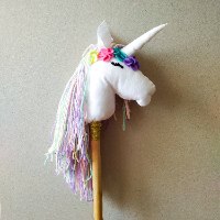 חד קרן על מקל עם שיער פסטל ופרח סגול