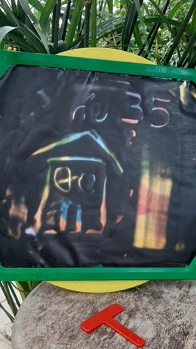 לוח ציור מחיק ייחודי, עם רקע שחור נוזלי עליו אפשר לצייר באמצעות מקל מצורף, הצבעים מתחלפים ע"י סיבוב הגלגל, פטנט ישראלי,