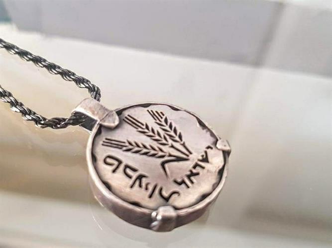 מטבע העצמה , To Be מאת ציפורה אוריה, תליון מטבע כסף במראה רטרו עליו חרוטים 3 שיבולים בהשראת מטבע אגורה של פעם, בתוספת המילה "טבעיות".